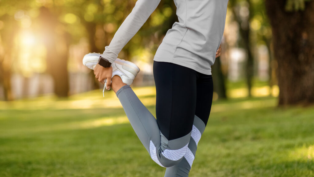 girl stretching legs at park